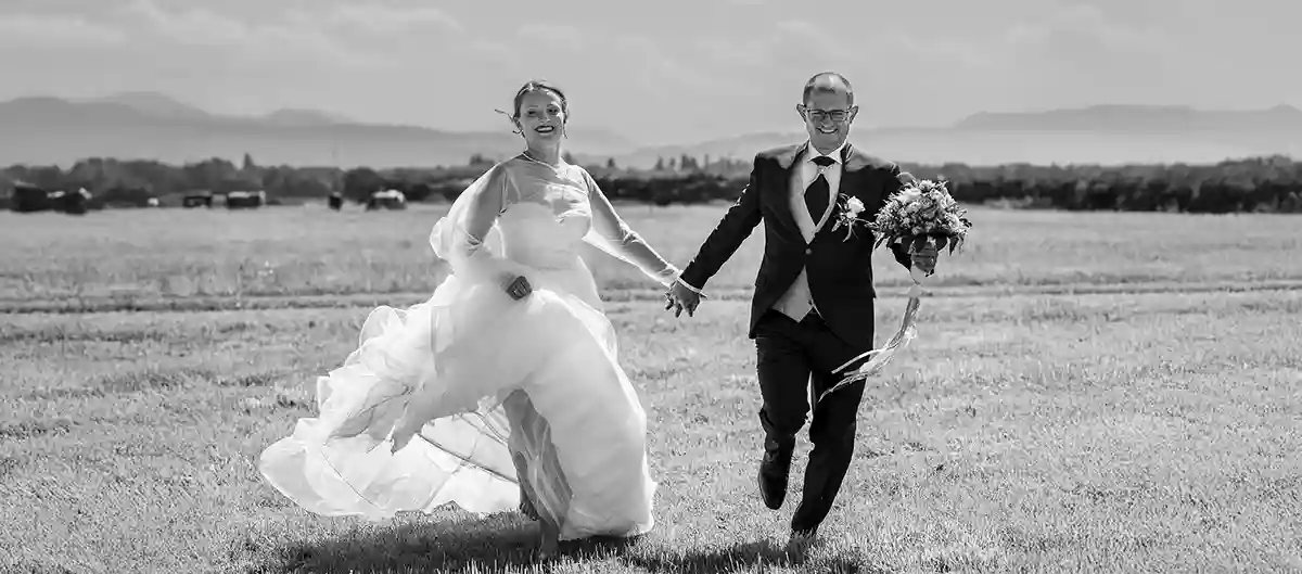 Brautpaar rennt über ein Feld